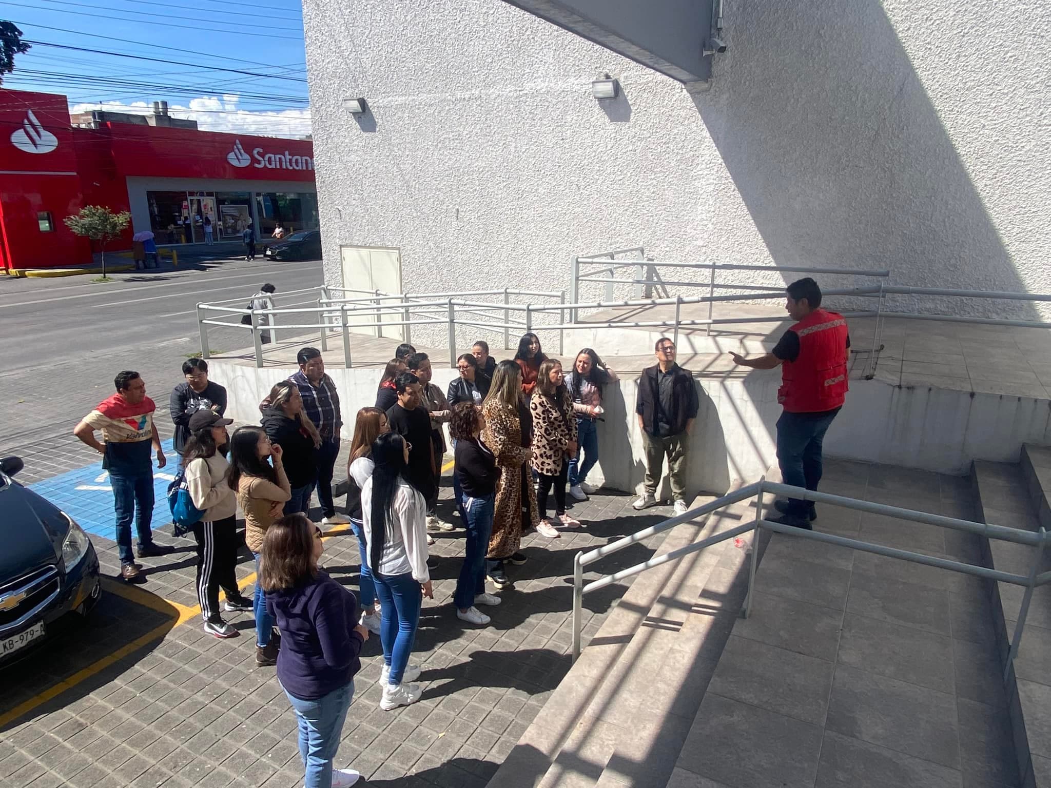 Simulacro de evacuación con personal reunido en el punto de reunión exterior de una sucursal