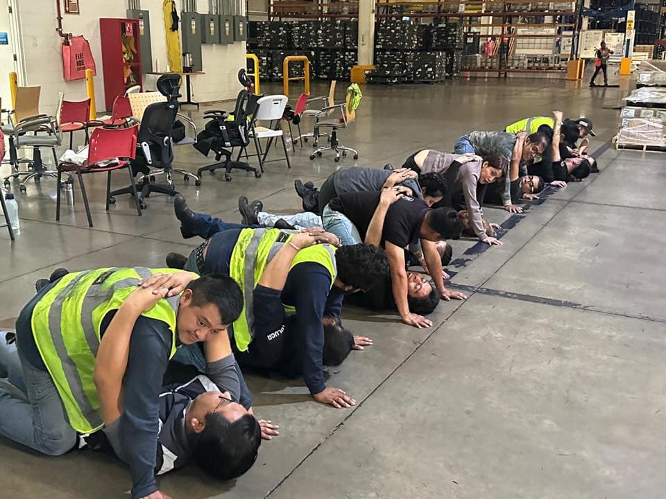 Personal con chalecos de seguridad practica primeros auxilios en un centro de distribución